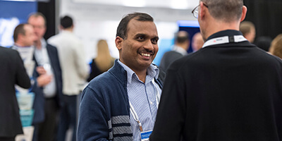 Attendee smiles at another during #GartnerAPPS Summit