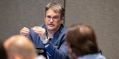 Engaged attendee leaning into a conversation with their peers in a session