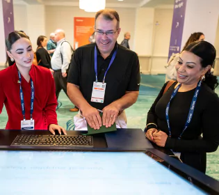 Gartner attendees networking across the conference and studying Gartner screen taking a deeper dive into supply chain.