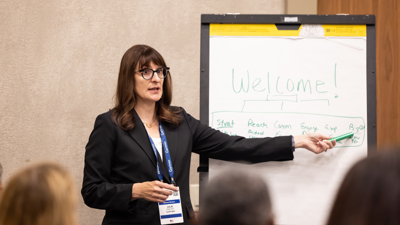 Speaker presenting at Gartner conference, emphasizing data-driven research and expert insights.