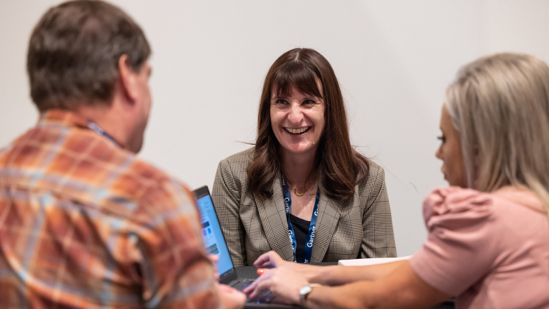 A team of conference attendees meeting with a Gartner expert for a collaborative discussion.