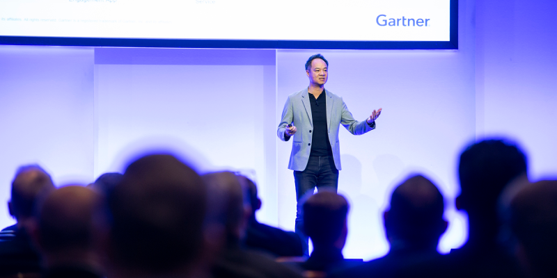 Speaker presenting at Gartner conference, emphasizing data-driven research and expert insights.