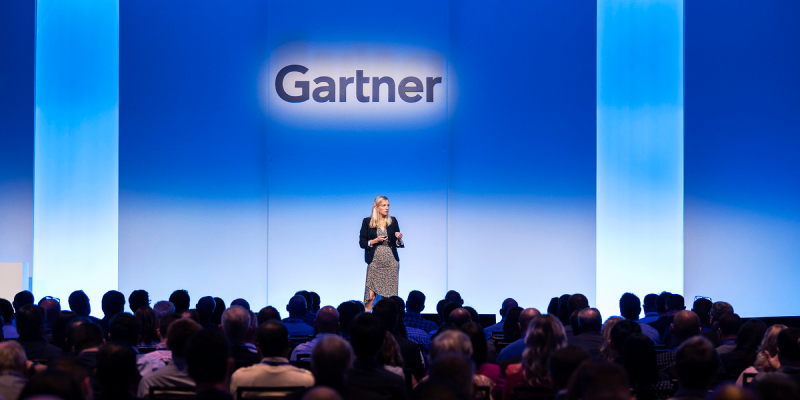 Speaker presenting at Gartner conference, emphasizing data-driven insights and expert advice..