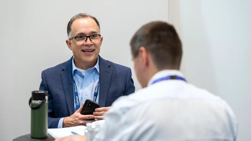 A Gartner expert meeting one-on-one with a conference attendee for a discussion.