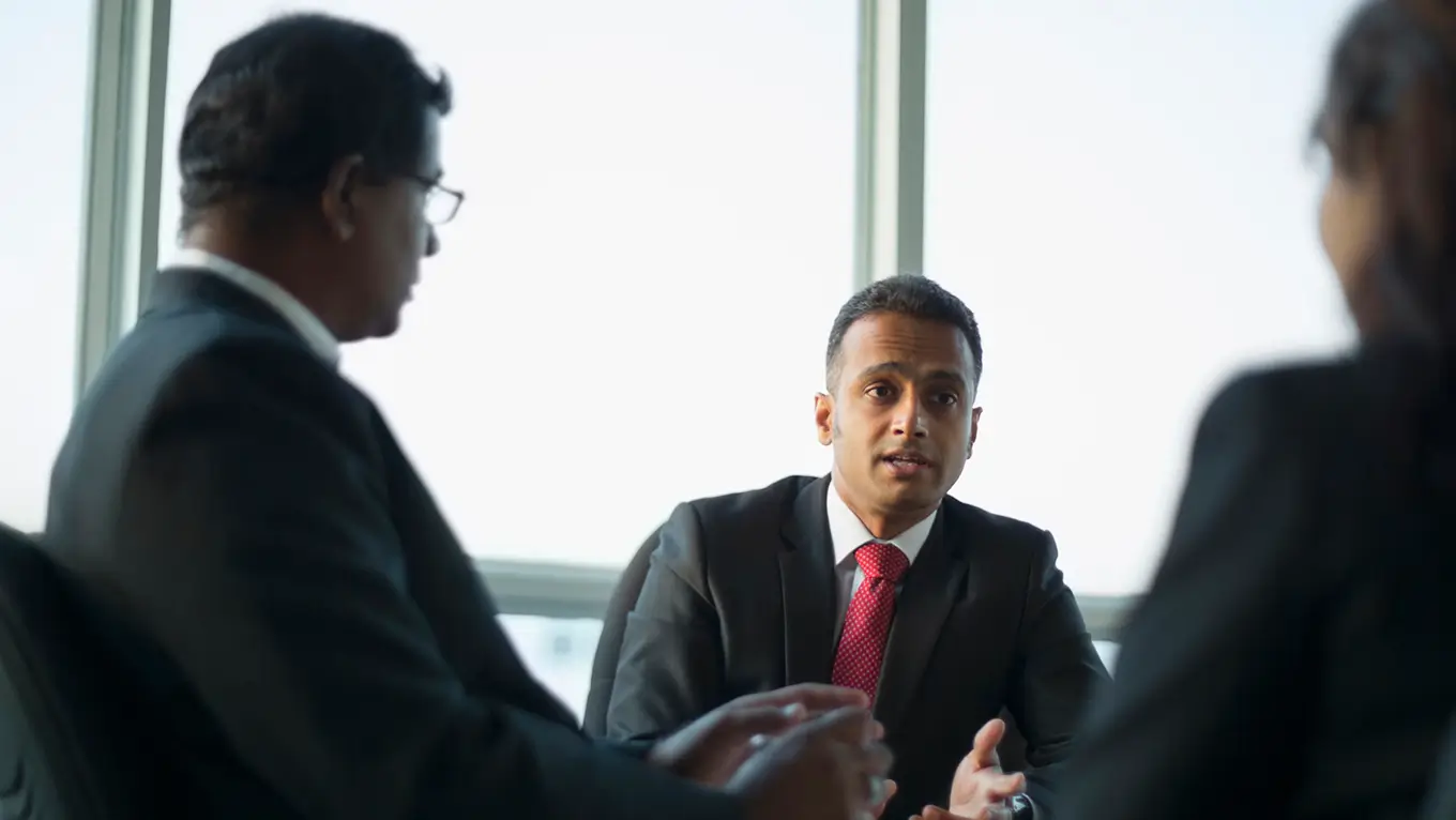 Tech practice leader meeting clients in a conference room.