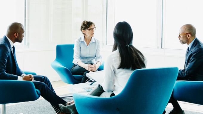 Tech practice leader meeting clients in a conference room.